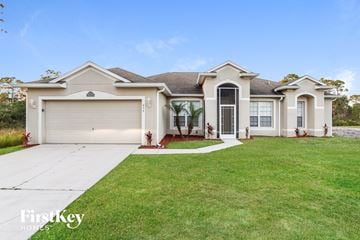 Palm Bay house for rent - a white house with a lawn and a driveway