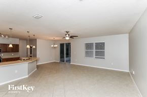 Palm Bay house for rent - an empty living room and kitchen with a ceiling fan