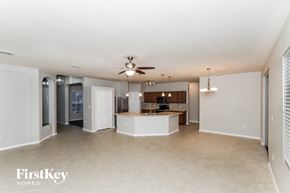 Palm Bay house for rent - an open kitchen and living room with a ceiling fan