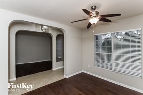 Palm Bay house for rent - an empty living room with a large window and a ceiling fan