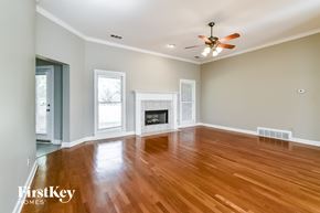 Cordova house for rent - A spacious room with a fireplace and wood flooring.
