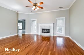 Cordova house for rent - A spacious living room with a fireplace and wood flooring.