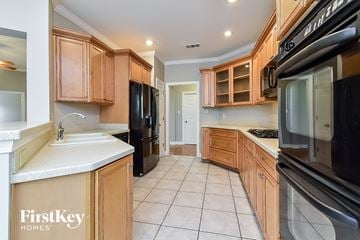 Cordova house for rent - A kitchen with wooden cabinets and black appliances.