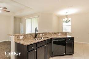 Green Cove Springs house for rent - a kitchen with black cabinets and a granite counter top