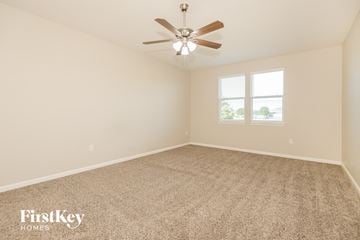 Green Cove Springs house for rent - a spacious living room with carpet and a ceiling fan