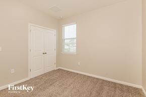 Green Cove Springs house for rent - a bedroom with carpet and a door and a window