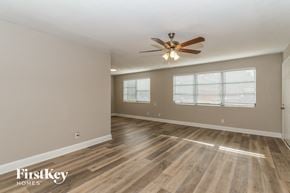 Jacksonville house for rent - A spacious room with a ceiling fan and wooden flooring.