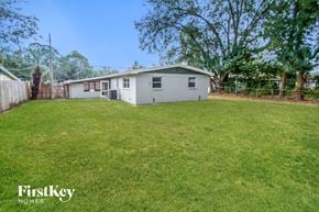 Jacksonville house for rent - A small house with a fence and trees in the background.