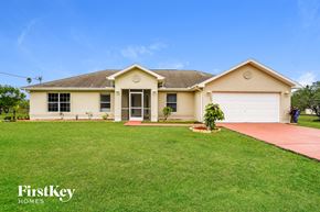 Lehigh Acres house for rent - A house with a red pathway leading to the front door.