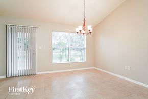 Lehigh Acres house for rent - A room with a sliding door and a window with a view of trees.