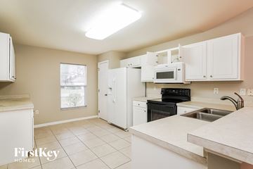 Lehigh Acres house for rent - A kitchen with white cabinets and appliances.