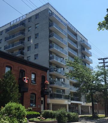 Ottawa apartment for rent - a tall apartment building with a brick building next to it