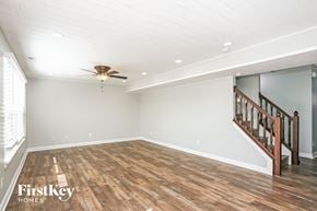Bargersville house for rent - A spacious room with wooden floors and a staircase.