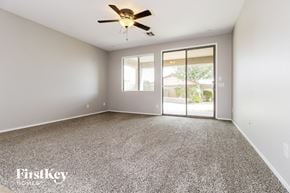 Buckeye house for rent - A spacious room with a ceiling fan and sliding glass doors.