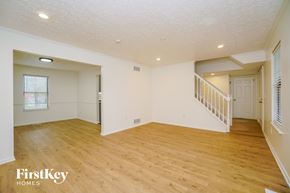 Dublin house for rent - A spacious room with wooden flooring and a staircase leading to another room.