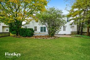 Dublin house for rent - A white house with a green lawn and trees in the background.