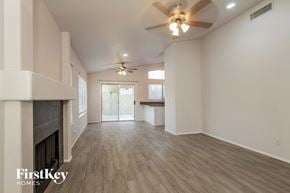 Phoenix house for rent - A spacious room with a fireplace and a ceiling fan.