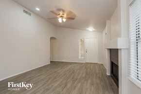 Phoenix house for rent - A spacious room with a fireplace and a ceiling fan.