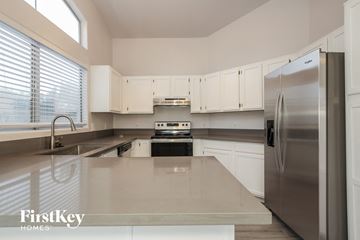 Phoenix house for rent - A kitchen with a stainless steel refrigerator and white cabinets.