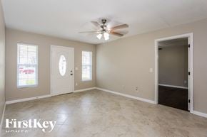 Jacksonville house for rent - A spacious room with a ceiling fan and two doors.