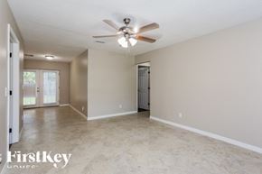 Jacksonville house for rent - A spacious room with a ceiling fan and tiled flooring.