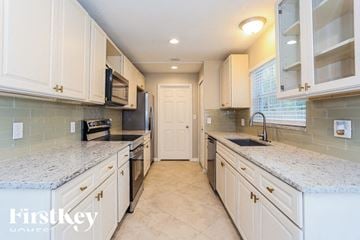 Jacksonville house for rent - A kitchen with white cabinets and granite countertops.