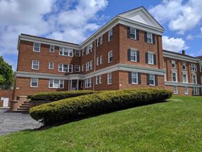 Shaker Heights apartment for rent - the front of a brick building with a lawn and bushes