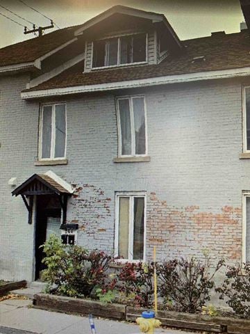 Ottawa apartment for rent - A house with a grey brick wall and a wooden door.