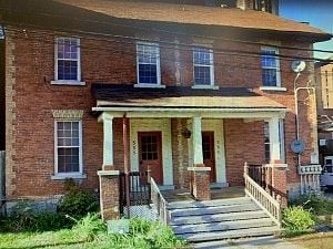 Ottawa apartment for rent - A red brick house with a porch and a front door.