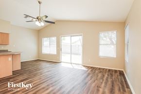 Goodyear house for rent - A spacious room with wood flooring and a ceiling fan.