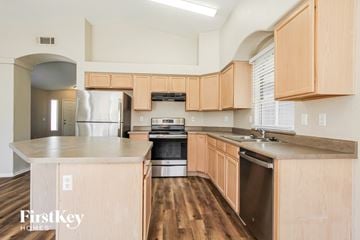 Goodyear house for rent - A kitchen with wooden cabinets and stainless steel appliances.