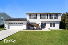North Port house for rent - a white house with a garage door and a lawn