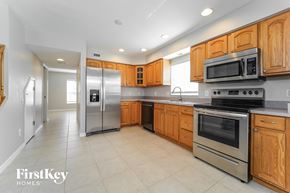 North Port house for rent - a large kitchen with stainless steel appliances and wooden cabinets