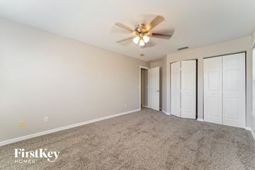 North Port house for rent - a spacious living room with carpet and a ceiling fan