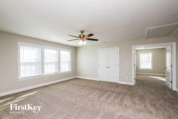 Mooresville house for rent - a living room with carpet and a ceiling fan