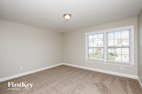Mooresville house for rent - a bedroom with a carpeted floor and two windows