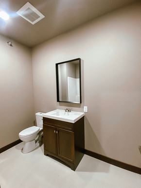 Watertown apartment for rent - A bathroom with a white toilet and a brown cabinet.