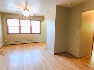 Fargo apartment for rent - a living room with wood floors and a window and a ceiling fan