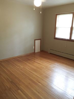 Fargo apartment for rent - an empty room with wooden floors and two windows