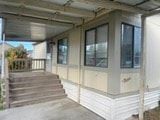 Grandview apartment for rent - A small house with a porch and stairs leading up to it.