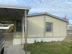 Grandview apartment for rent - A mobile home with a covered porch and a car parked in front.