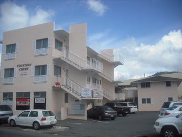 Honolulu apartment for rent - an apartment building with cars parked in front of it