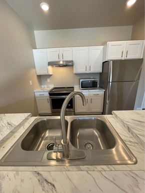 Devils Lake apartment for rent - a kitchen with a sink and a stainless steel refrigerator