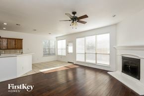 Fort Worth house for rent - a living room with a fireplace and a ceiling fan
