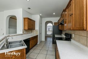 Fort Worth house for rent - a kitchen with white counter tops and wooden cabinets and a sink