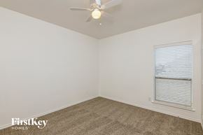 Fort Worth house for rent - a bedroom with a ceiling fan and a window