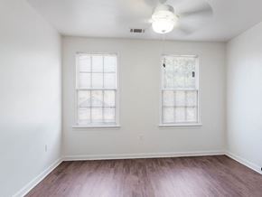 New Orleans apartment for rent - an empty living room with wood floors and two windows