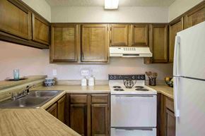 Temple apartment for rent - a kitchen with white appliances and wooden cabinets