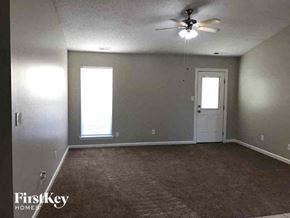 Monroe house for rent - A room with a carpeted floor, a ceiling fan, and a door.