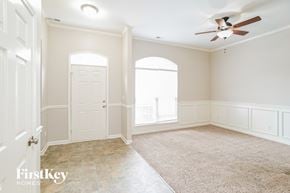 Indian Trail house for rent - A spacious room with a carpeted floor, a ceiling fan, and a door leading to another room.